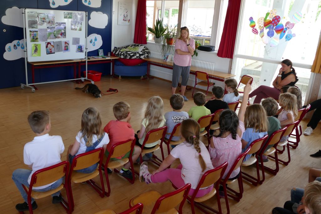 Kinder auf Stühlen in der Aula